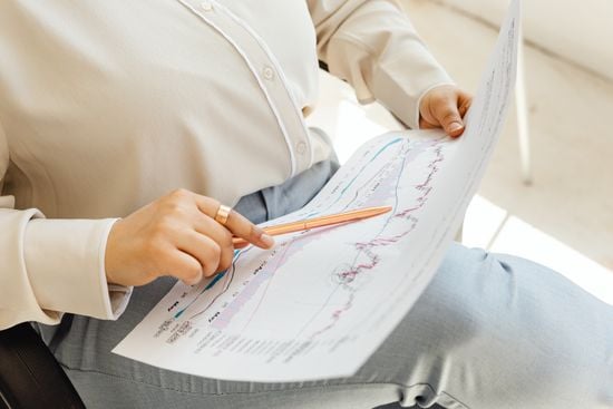 Business professional reviewing financial charts and performance trends to assess changing priorities as the company scales.